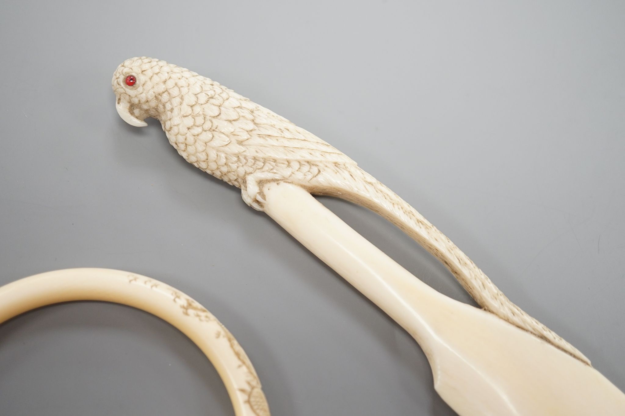 A late 19th century carved ivory ‘parrot’ paper knife and two Japanese carved Ivory bangles, paper knife 22 cms long.